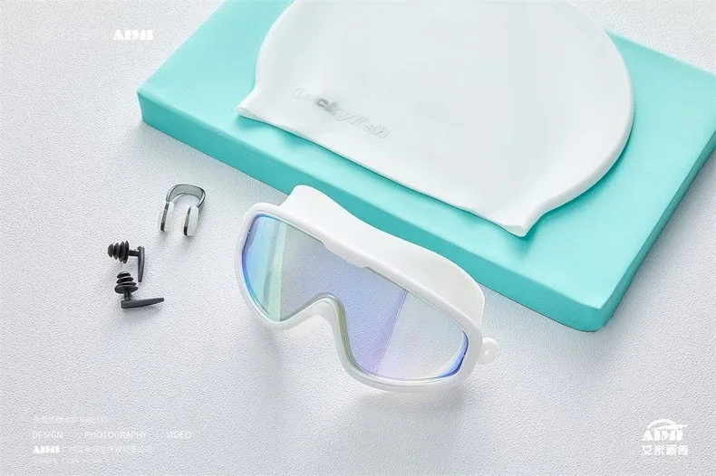 Product photography — swim goggles and cap set on clean background