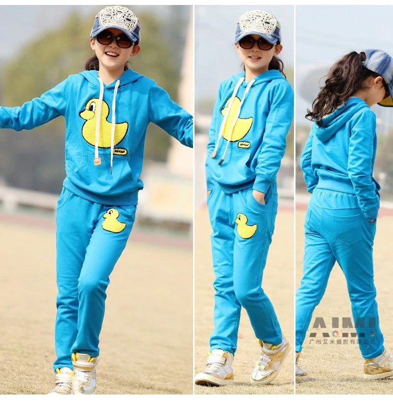 Triptych of the blue duck sweatsuit showing front, angled and rear views on a grass field