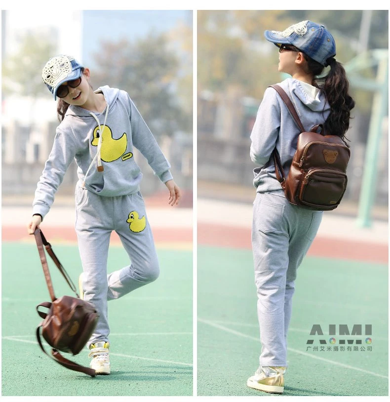 Diptych of the grey duck sweatsuit with a brown mini backpack on a sports court