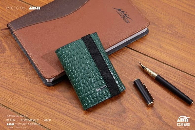 Green croc-embossed leather card case with planner and pen - desk scene product photography