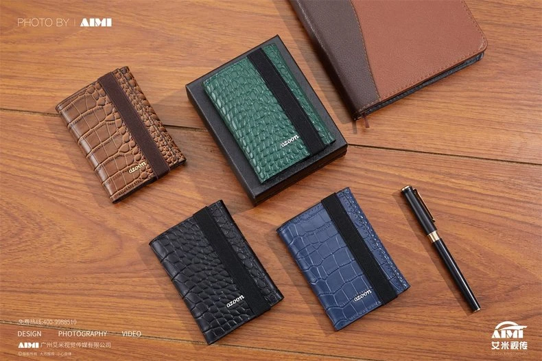 Four croc-embossed card holders in tan green black and navy - leather series flat lay photography