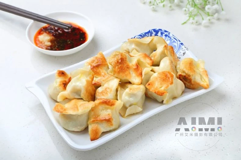 Pan-fried potstickers with golden crispy bases on a white plate