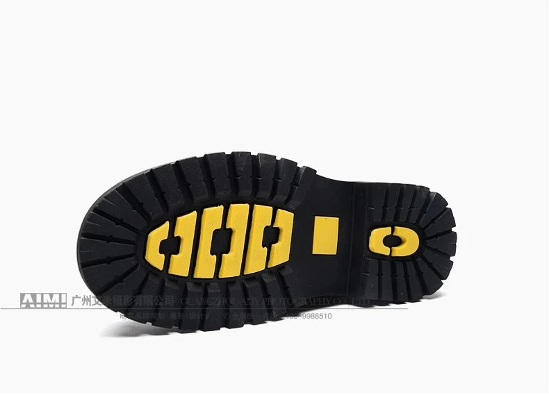 Lugged rubber work-boot outsole with yellow traction inserts, top-down tread frame on white