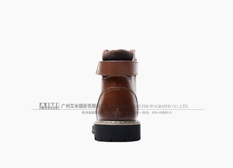 Brown leather ankle boot with rear strap, straight-on heel view on a white background