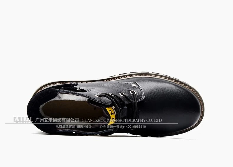 Black fur-lined leather work boot laid on its side showing the white shearling collar and lug sole
