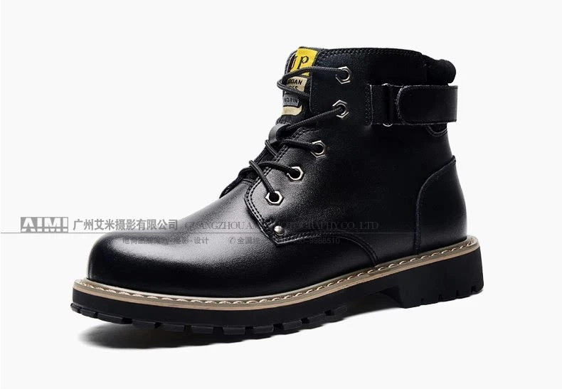 Black leather work boot with side buckle strap and yellow tongue label, profile packshot on white