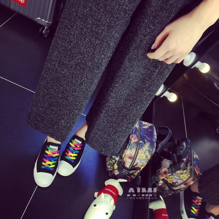 Black platform canvas sneakers with rainbow laces doubled in a vanity mirror reflection