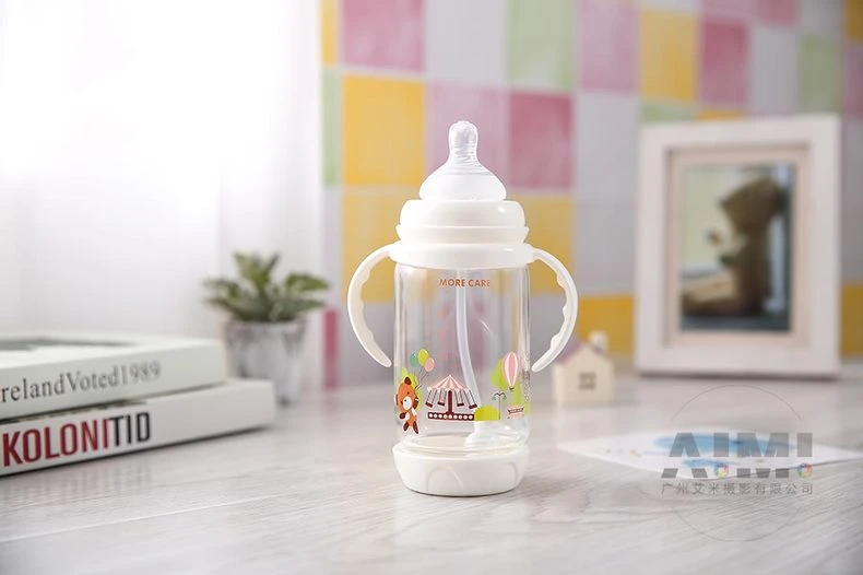 MORE CARE anti-colic baby bottle with carousel print, weighted straw and handles on pale wood table, nursery lifestyle photography
