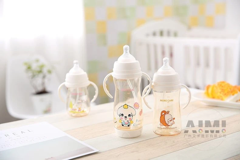 Three MORE CARE baby bottles in amber PPSU and clear bodies with puppy and rabbit prints, nursery group product photography