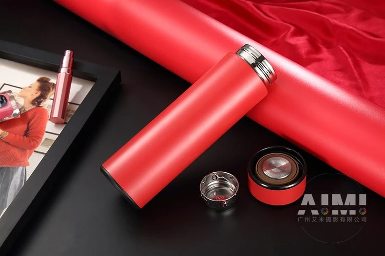 Red flask with lid and strainer on reflective black - red thermos photography