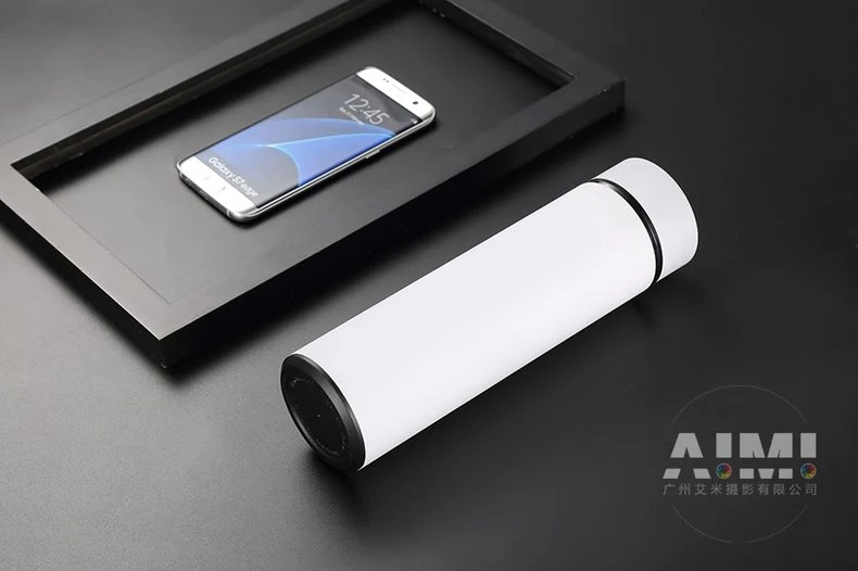 White flask with smartphone in black tray - minimal flask photography
