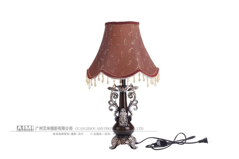 Lit amber table lamp glowing on white - illuminated lamp photography