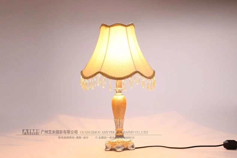 Warm glowing vintage lamp with tassel shade - lit lamp photography